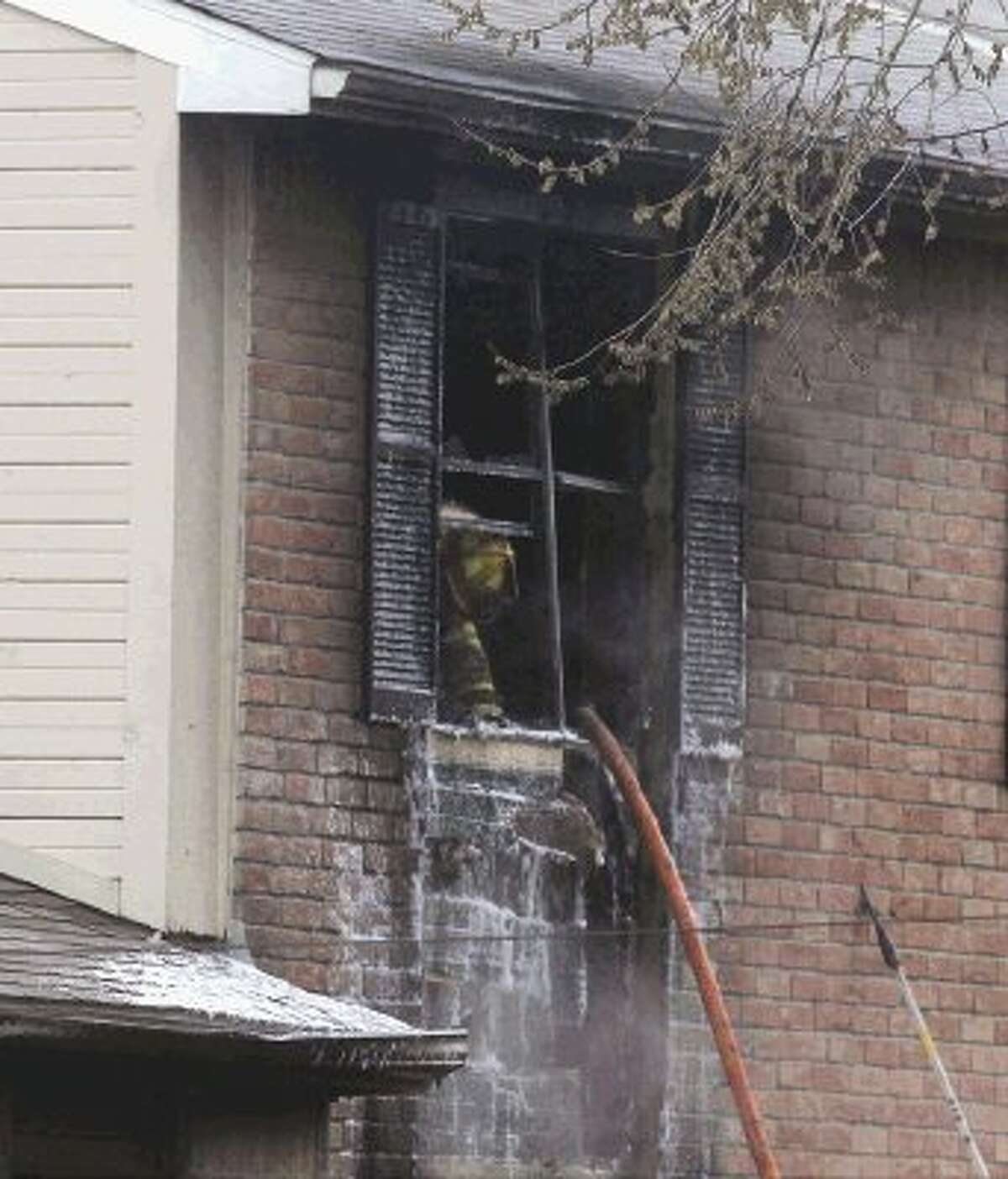 A firefighter works the scene of a fire at Abbey at Conroe Apartments Saturday.