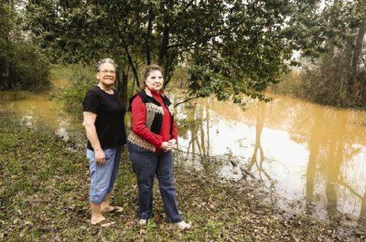 Robbie Sheffield, Center Hill Baptist Church building and grounds keeper, left, and Barbara Hull, treasurer and custodian, right, stand next to the water that has flooded the church property in Willis due to the construction of a water bottling plant next door.