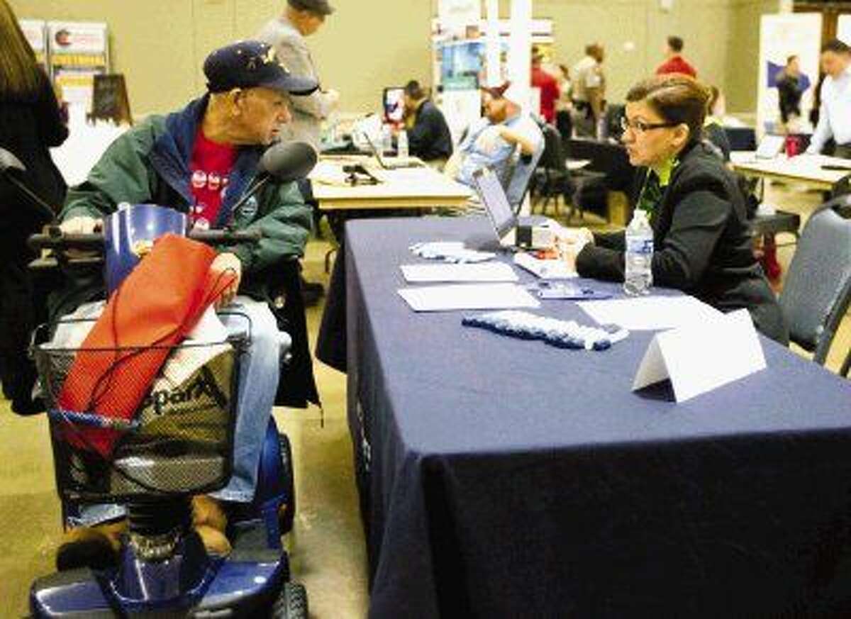 Former Navy photographer Earnest Crane talks with a job recruiter during a veteran’s expo and hiring event Tuesday, March 17, at Lone Star Convention and Expo Center.