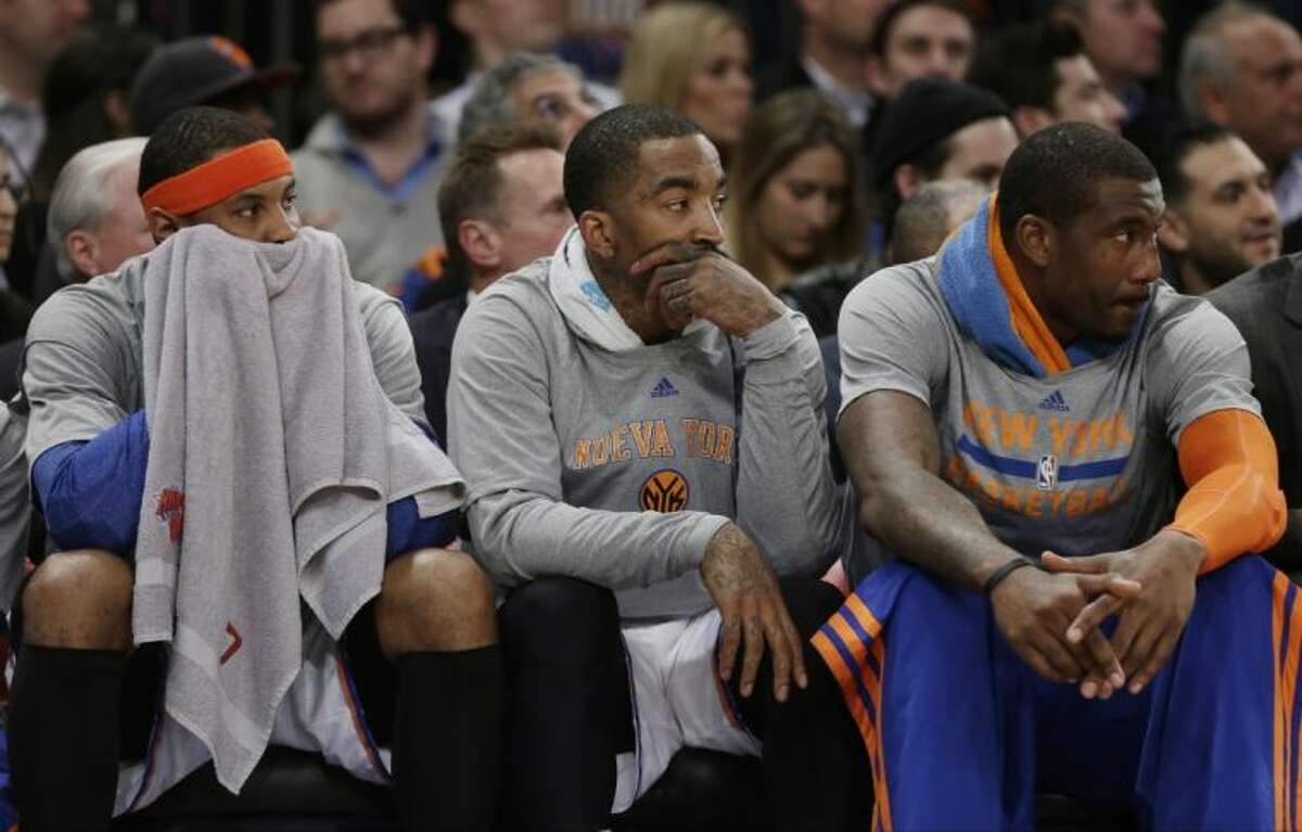 From left, New York Knicks Carmelo Anthony, J.R. Smith and Amar’e Stoudemire look on during the first half of a 123-110 victory against the Philadelphia 76ers on Monday in New York.