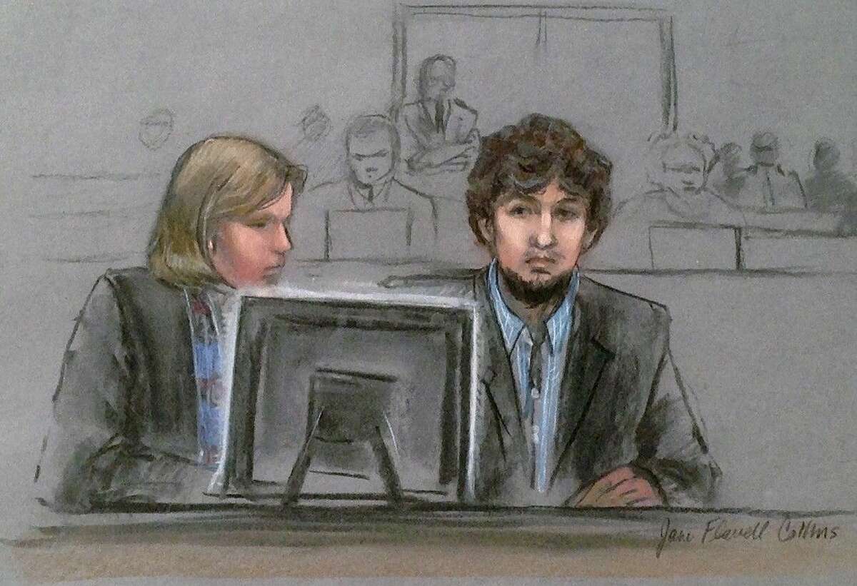 In this courtroom sketch, Dzhokhar Tsarnaev, right, and defense attorney Judy Clarke are depicted watching evidence displayed on a monitor during his federal death penalty trial Monday, March 9, 2015, in Boston.