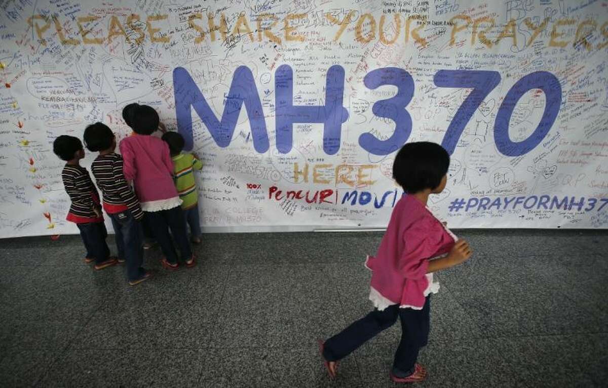 Children read messages and well wishes displayed for all involved with the missing Malaysia Airlines jetliner MH370 on the walls of the Kuala Lumpur International Airport, Thursday, March 13, 2014 in Sepang, Malaysia. Planes sent Thursday to check the spot where Chinese satellite images showed possible debris from the missing Malaysian jetliner found nothing, Malaysia's civil aviation chief said, deflating the latest lead in the six-day hunt. The hunt for the missing Malaysia Airlines flight 370 has been punctuated by false leads since it disappeared with 239 people aboard about an hour after leaving Kuala Lumpur for Beijing early Saturday.