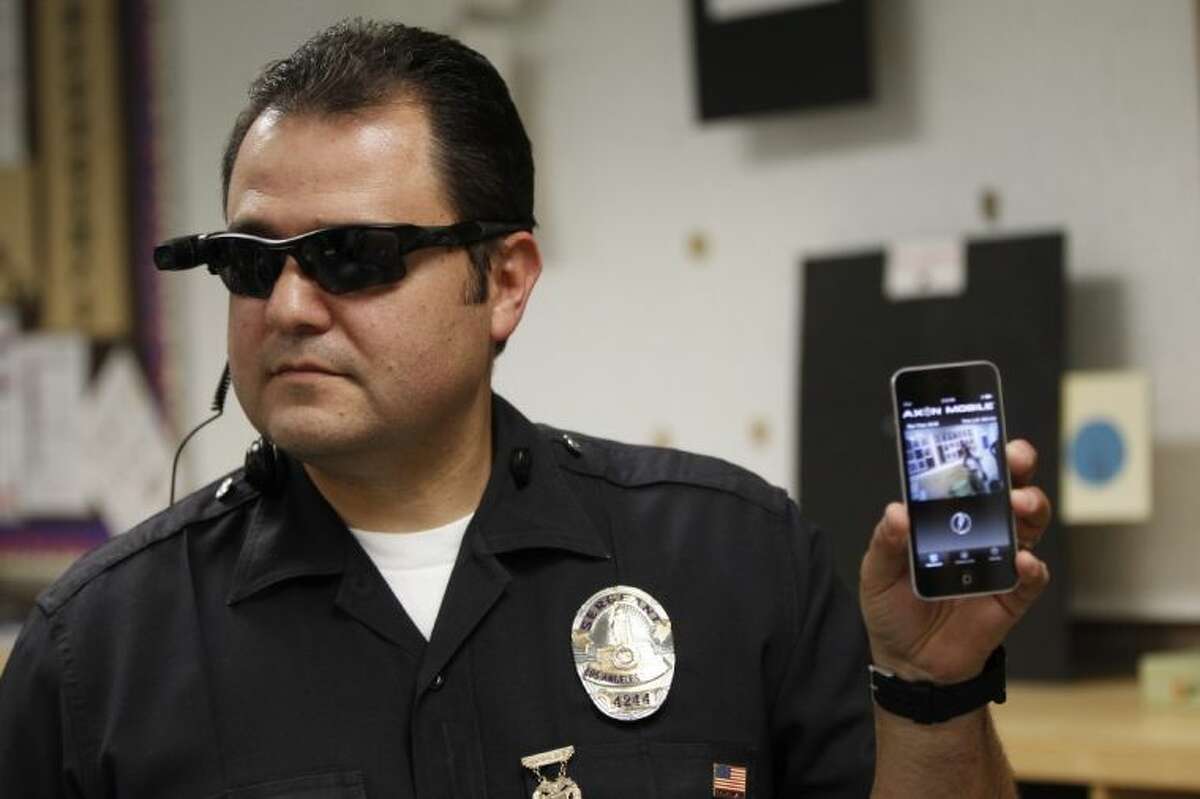 This Jan. 15, 2014 file photo shows Los Angeles Police Sgt. Daniel Gomez demonstrating a video feed from his camera into his cellphone as on-body cameras are demonstrated for the media in Los Angeles. Thousands of police agencies have equipped officers with cameras to wear with their uniforms, but they’ve frequently lagged in setting policies on how they’re used, potentially putting privacy at risk and increasing their liability. As officers in one of every six departments across the nation now patrols with tiny lenses on their chests, lapels or sunglasses, administrators and civil liberties experts are trying to envision and address troublesome scenarios that could unfold in front of a live camera.
