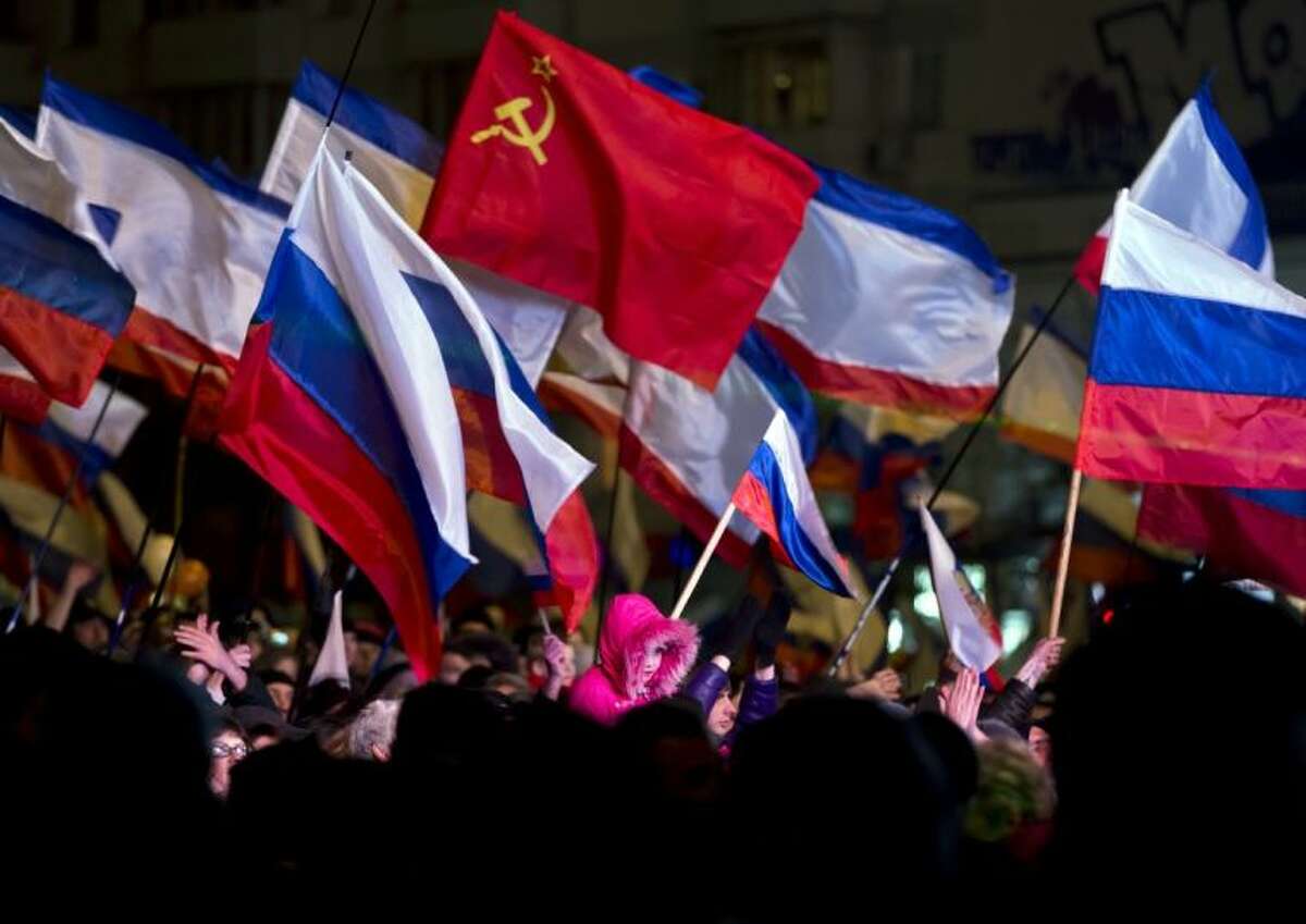 Pro-Russian people celebrate in Lenin Square, in Simferopol, Ukraine, Sunday, March 16, 2014. Fireworks exploded and Russian flags fluttered above jubilant crowds Sunday after residents in Crimea voted overwhelmingly to secede from Ukraine and join Russia.
