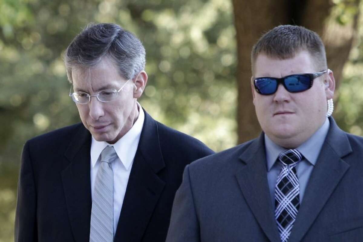 In this Aug. 3, 2011 file photo, Polygamist religious leader Warren Jeffs, left, arrives at the Tom Green County Courthouse escorted by a law enforcement officer in San Angelo, Texas.
