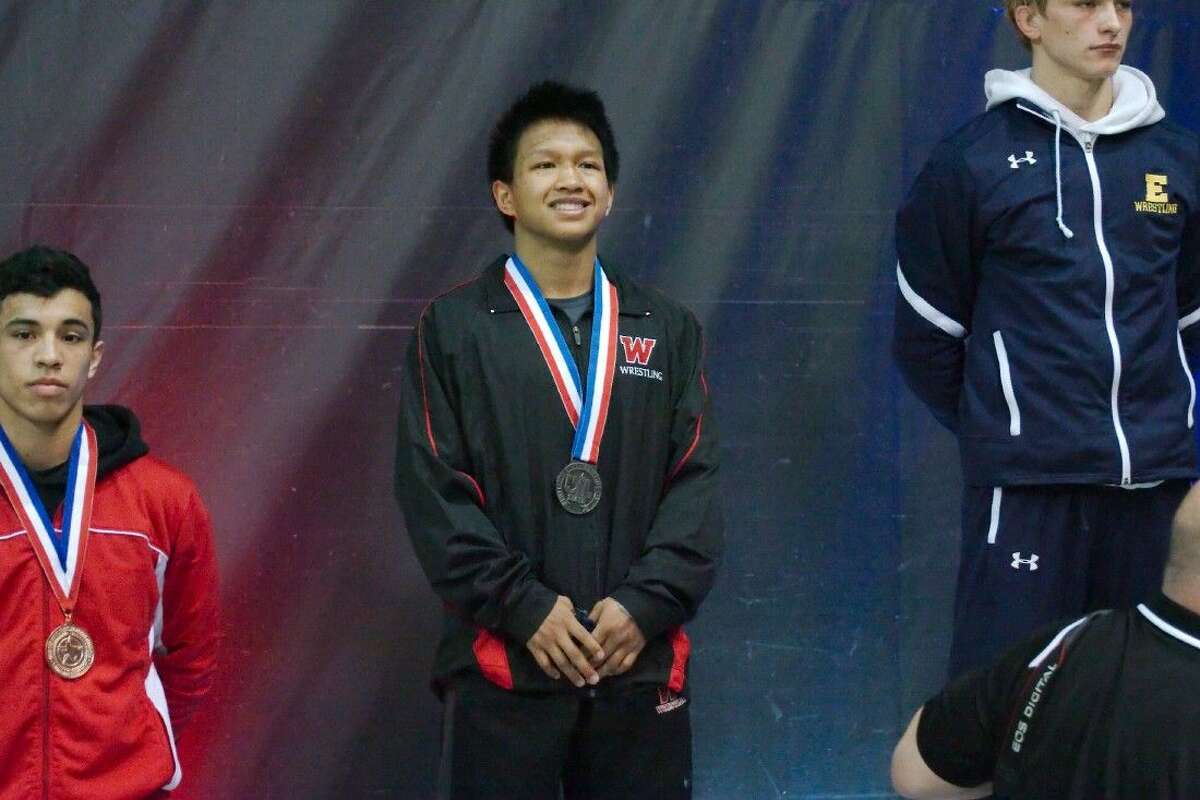 The Woodlands' Nathaniel Adea receives his medal for finishing second in the UIL State Wrestling finals Saturday.