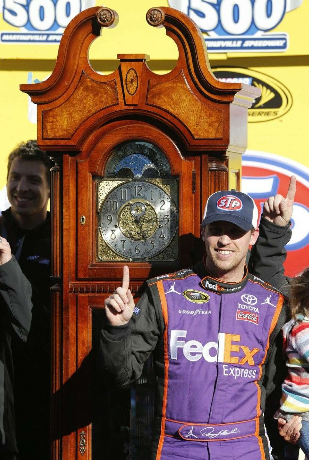 Denny Hamlin poses next to the winner's trophy after the NASCAR Sprint Cup Series auto race at Martinsville Speedway.