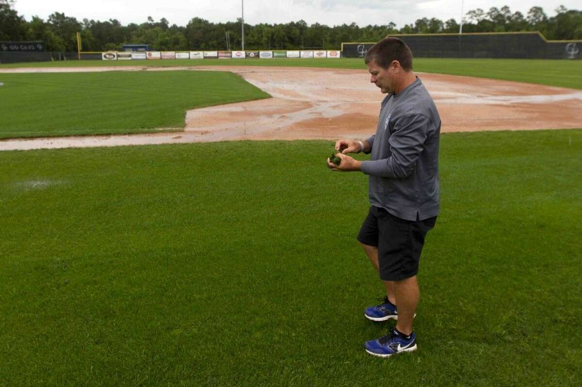 College Park head coach Jason Washburn surveys the baseball field as rain continues to come down at College Park High School Wednesday.