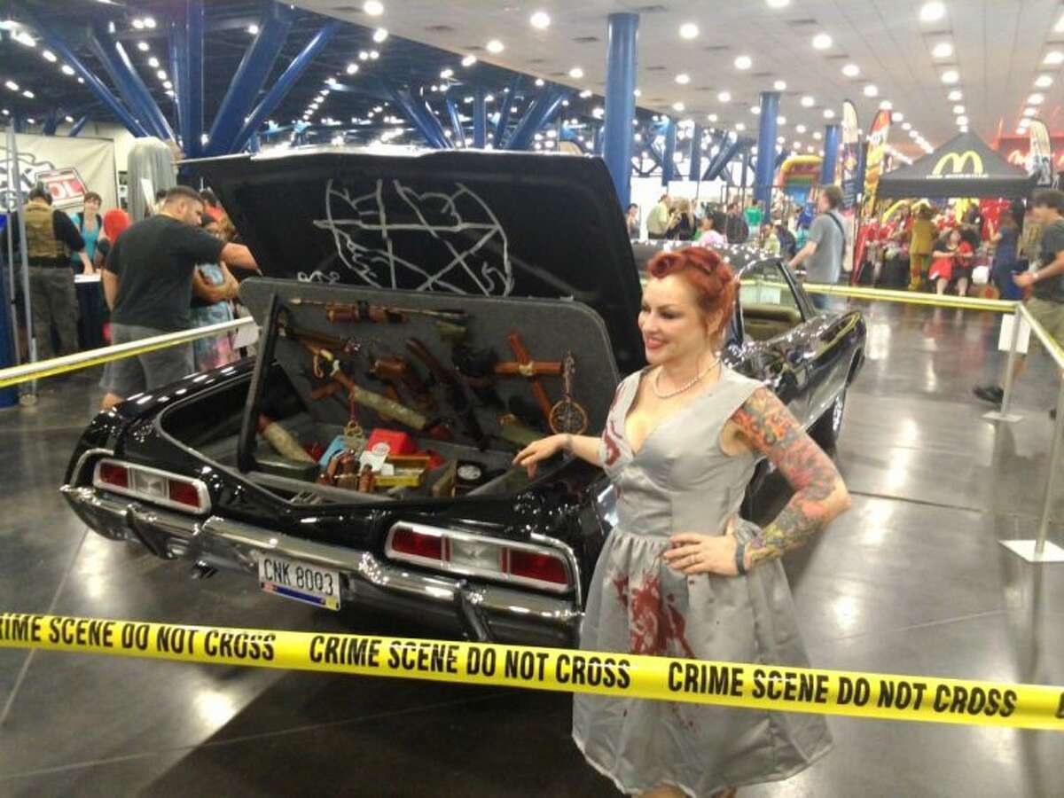 A cosplayer (short for costume player, is a performance art where participants wear costumes and accessories to represent a specific character) dressed as Abbadon from the CW series “Supernatural” poses with the weapons trunk of Magnolia couple Adam and Lisa Diamont’s replica of “Baby,” the 1967 Chevy Impala from the series at Comicpalooza 2014 at the George R Brown Convention Center Memorial Day weekend.
