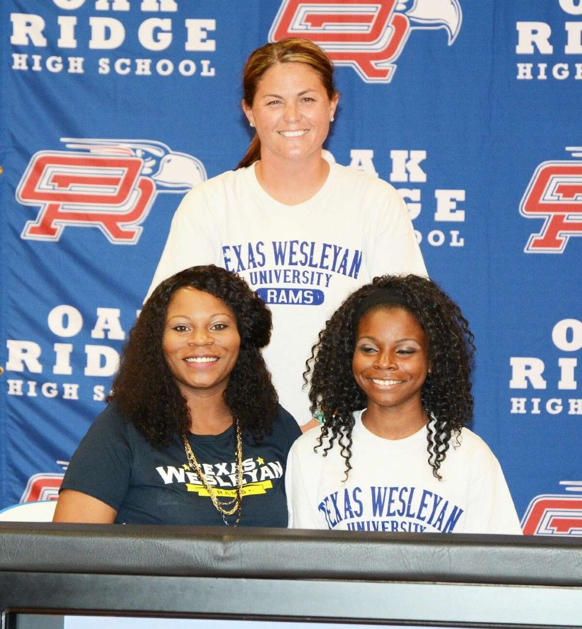 Oak Ridge’s Kaelah Brewer (front right) poses with her family and coach Kristina Dube (back) after signing her National Letter of Intent to run track at Texas Wesleyan University.
