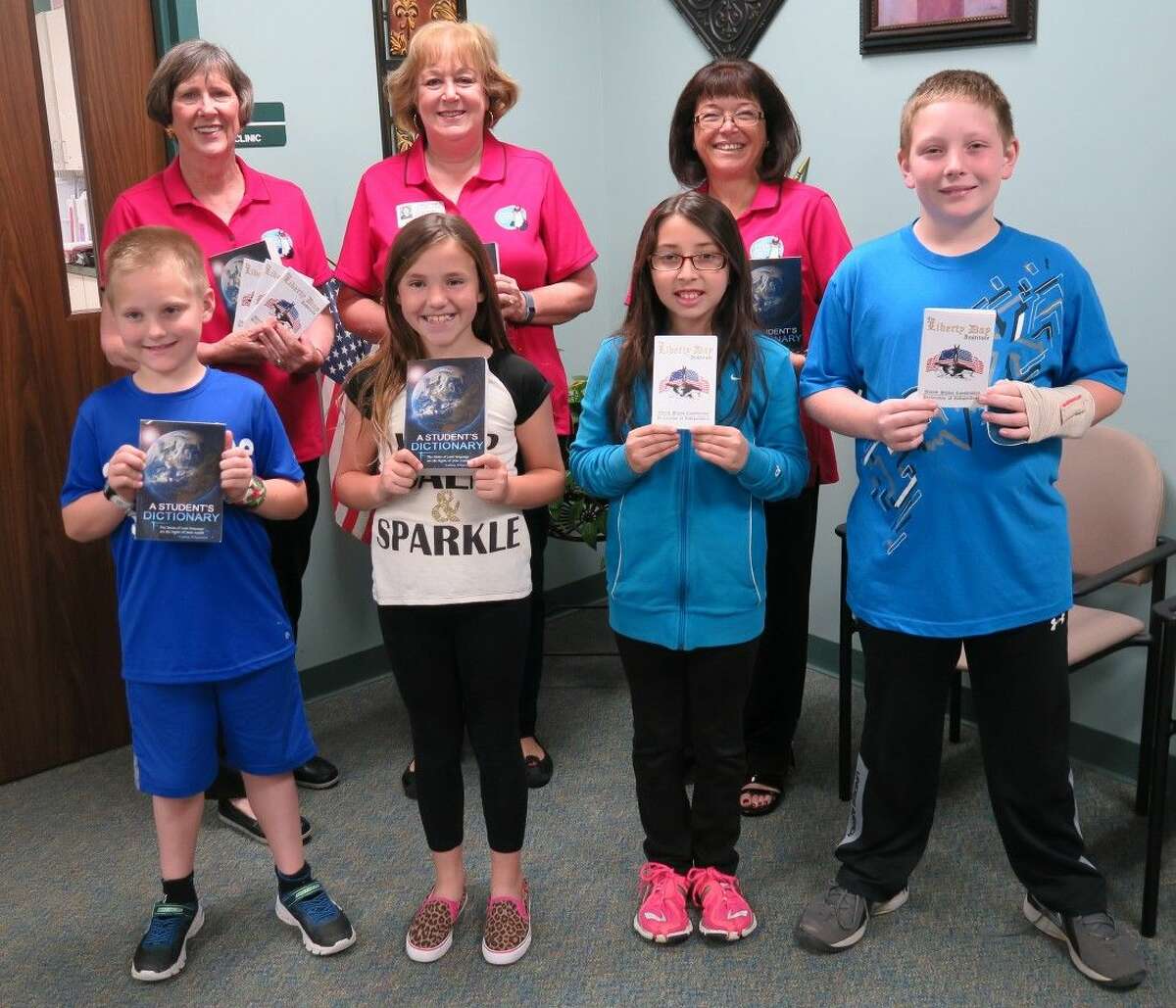 Front row: Dictionaries were presented to Meador Elementary third grade students Colson Solberg and Mallori Mitchell, and Belkys Benitez and Carson Haefner, fifth graders, received Constitution booklets.Back row, Ann Kate, NSRW Media Chairman; Judy Love, NSRW Literacy/Youth Outreach Chairman; and Gail McKinnon, NSRW President.