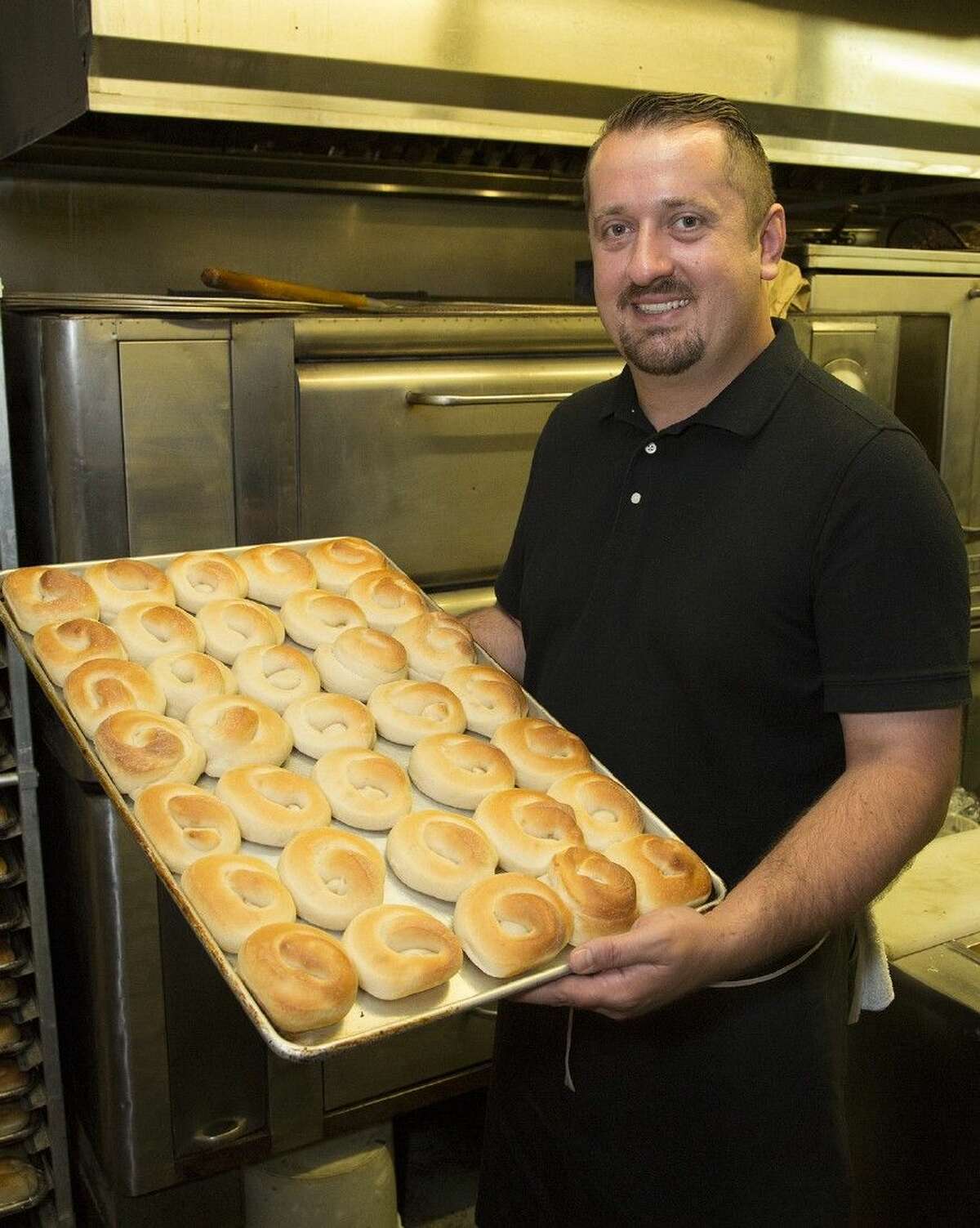Joe Haliti, owner of Joe’s Italian Restaurant in Conroe, displays a pan of his famous yeast rolls.