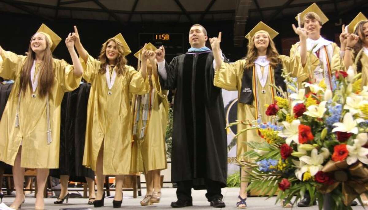 Dr. Mark Weatherly joins in singing with the Class of 2014 choir graduates at Conroe High School’s graduation May 31, the last graduation to be held at Johnson Coliseum in Huntsville.