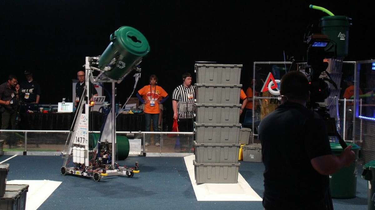 Texas Torque’s robot attempts to set a plastic trash can on top of the already-completed box tower — one of the ways the teams can earn points toward advancing.