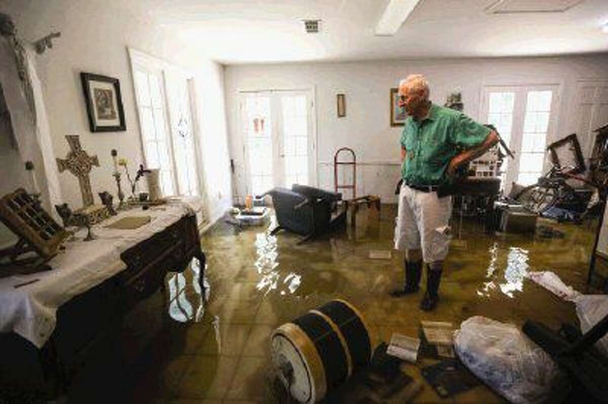 River Plantation resident Kenneth Walsh on Sunday surveys damage to the home he and his wife Eileen share.