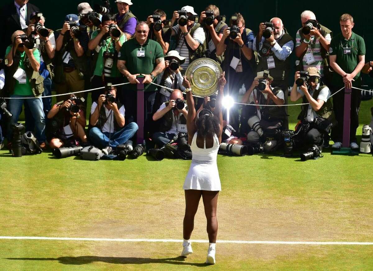 Serena Williams of the United States holds up the trophy toward the media after winning the women's singles final against Garbine Muguruza of Spain at the All England Lawn Tennis Championships in Wimbledon, London, Saturday.