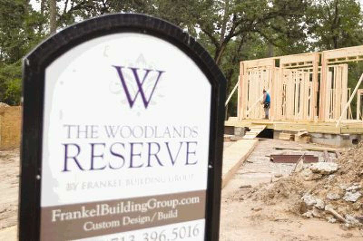 Construction workers continue building a model home at The Woodlands Reserve Friday.