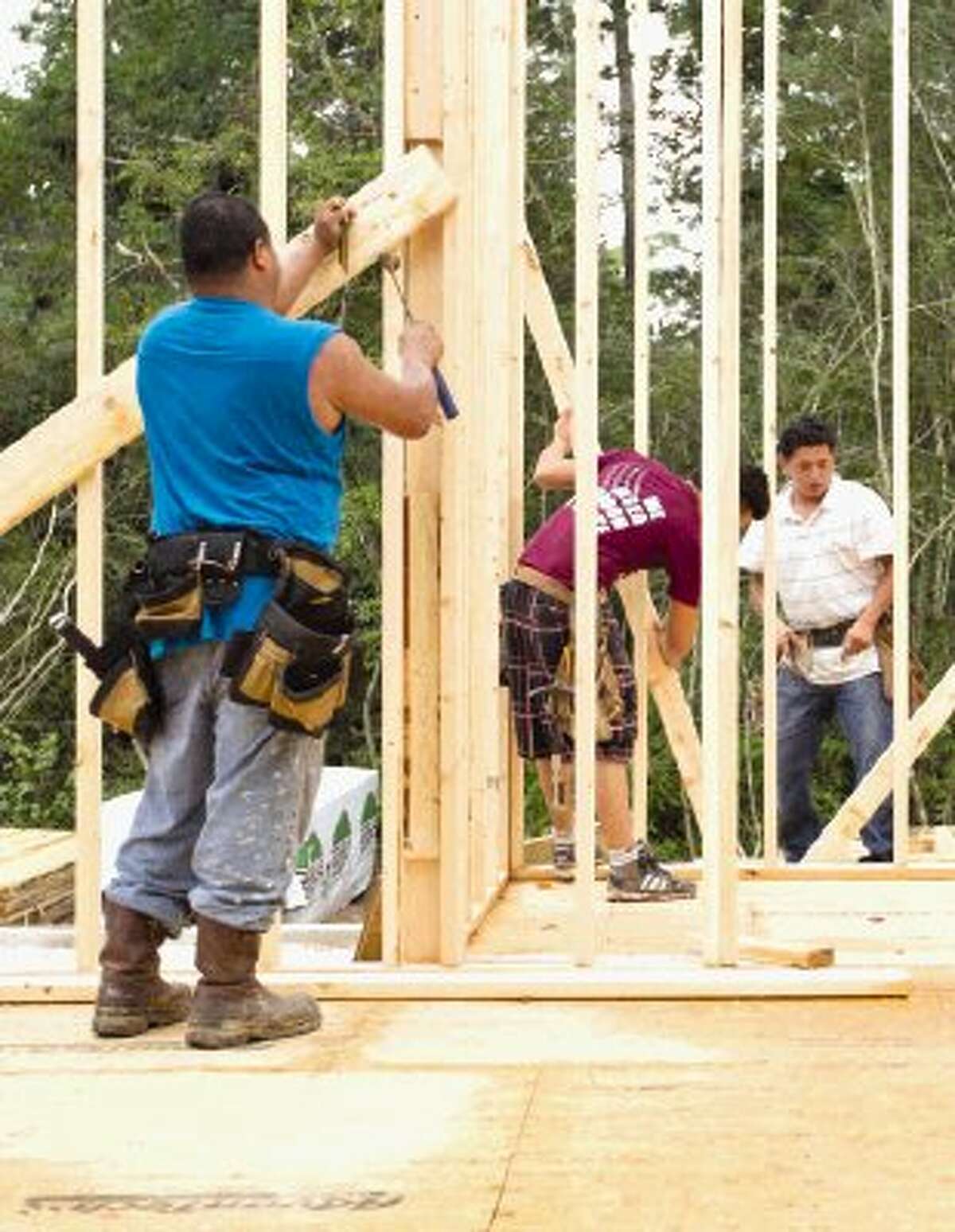 Construction workers continue building a model home at The Woodlands Reserve Friday.