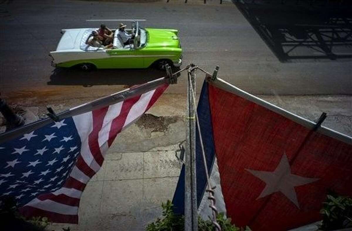 A U.S., and a Cuban national flag, hang from a balcony to mark the restored full diplomatic relations between Cuba and the Unites States, in Old Havana, Monday. The new era began with little fanfare when an agreement between the two nations to resume normal ties on July 20 came into force just after midnight Sunday and the diplomatic missions of each country were upgraded from interests sections to embassies.