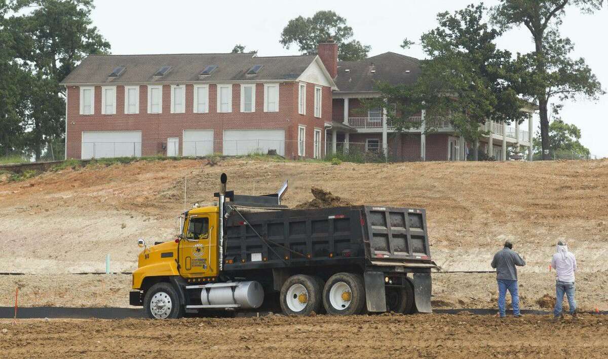 Construction on the Wedgewood Forest development takes place beneath a large home at 775 Indian Hills Drive in Conroe. Prior to the trees being cleared for the development, the house was mostly hidden by the trees. It currently owned by Land Tejas, the company developing the Wedgewood Forest subdivision.