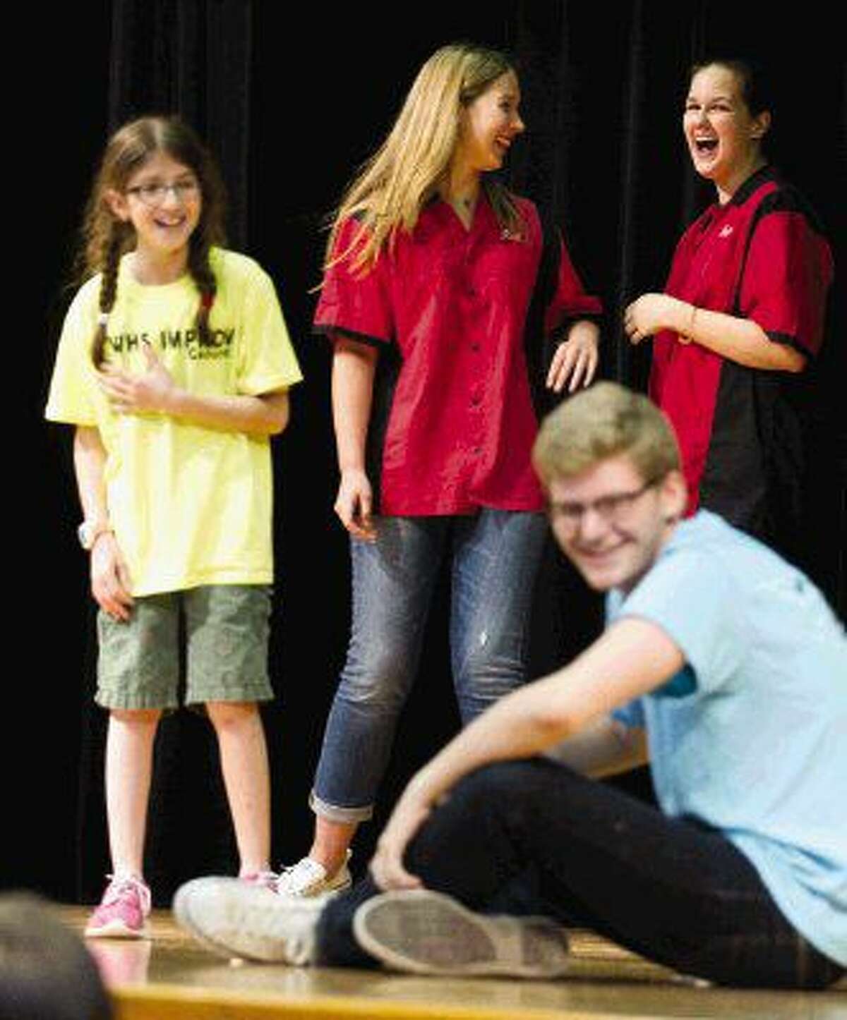 The Woodlands High School Improv Troupe members Katerina Meyerl, center, and Brenna Lelicah laugh as Mitchell Intermediate School students Rotem Rics and Jason Leach go through a skit at Mitchell Intermediate School Wednesday.
