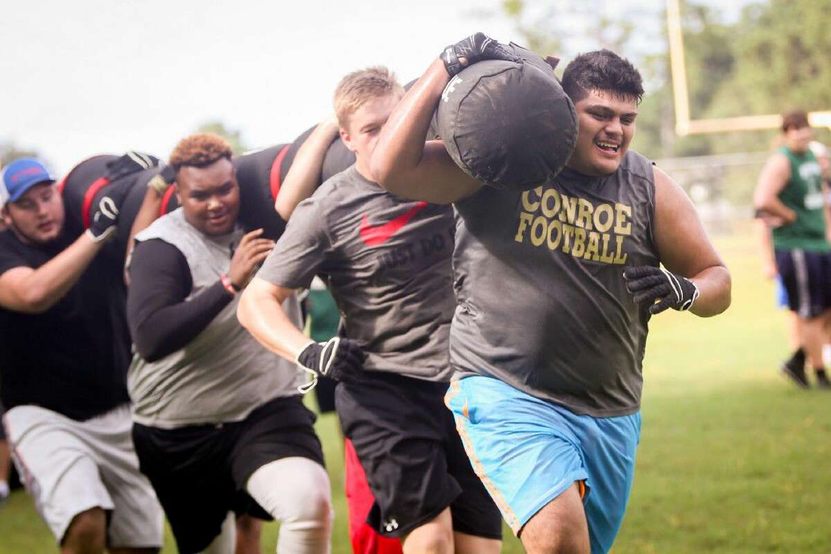 Conroe linemen participate in the Worm Carry event during the Oak Ridge War Zone Lineman Challenge on Saturday at Oak Ridge High School.