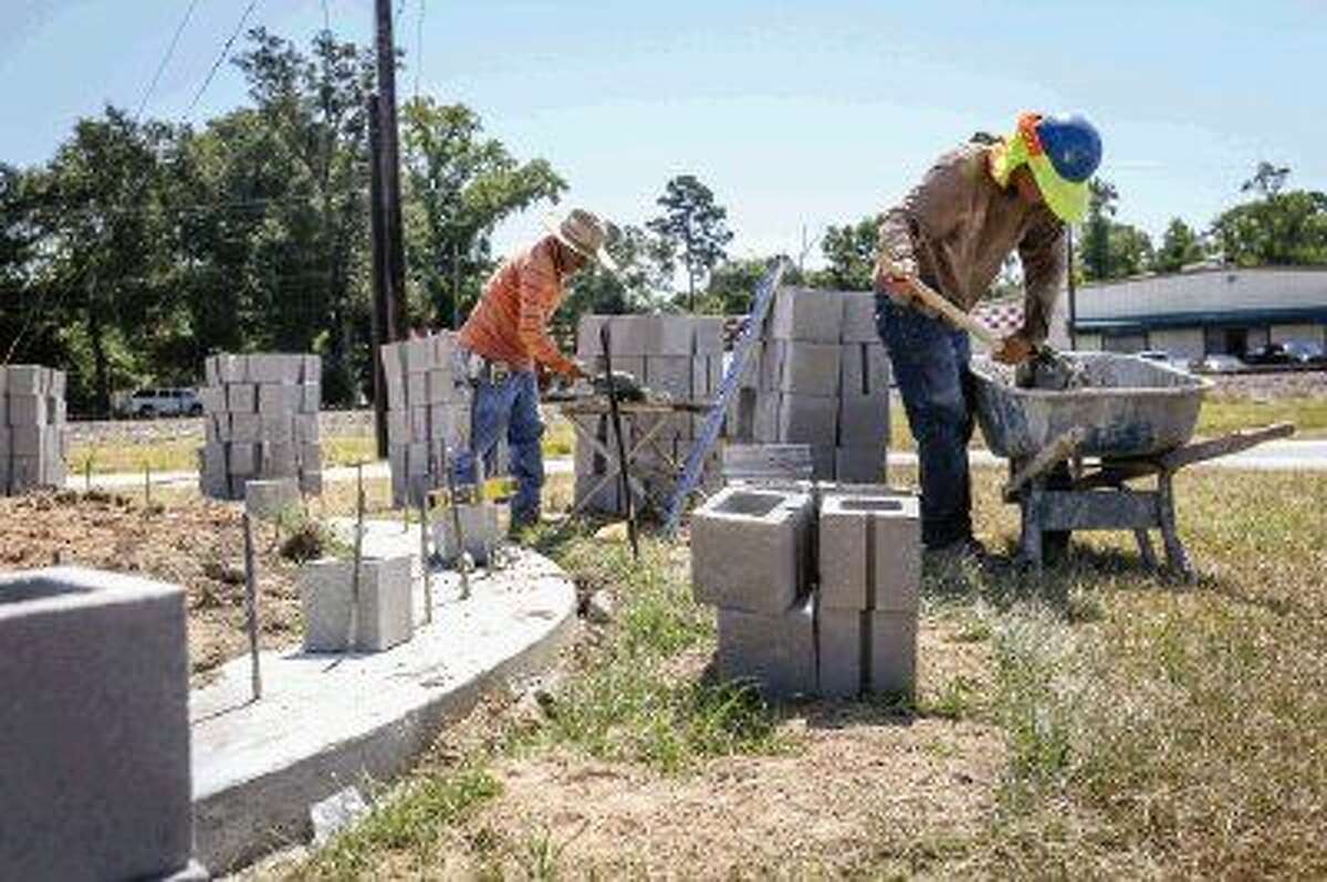 Construction workers build the third gateway into Conroe Monday off of Frazier Street near at Gladstell and Main.