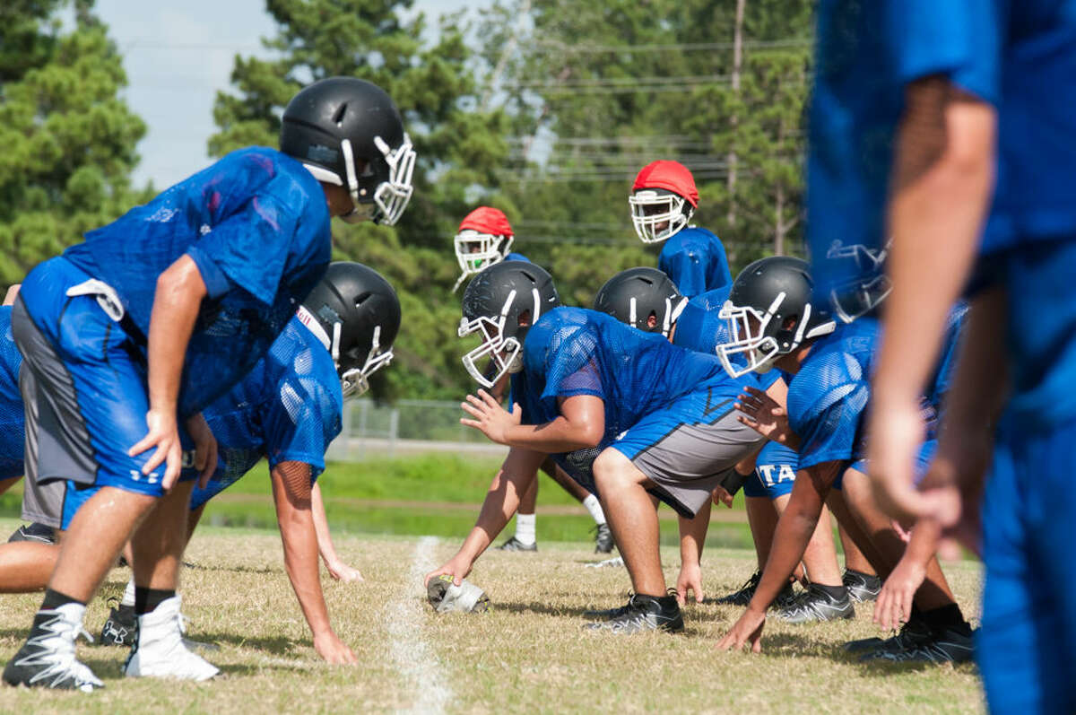The New Caney defense lines up against the scout team during a practice earlier this month at New Caney High School.