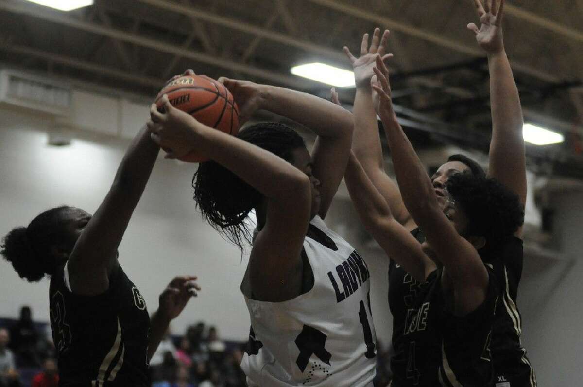 Tigerettes Erica Powell, C.J. Lewis and Yulisa Peralta swarms Willis’ Cheyla Perry on a rebound during Tuesday night’s opening game at Willis.