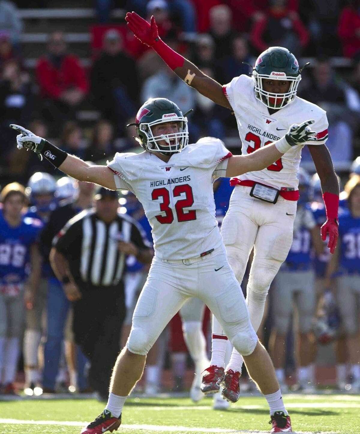 The Woodlands linebacker Matt Mahoney and defensive back Talon Baskin signal for possession after the Highlanders recoverd a Westlake fumble during the first quarter of a Region II-6A Division II area playoff football game Saturday in Bryan.