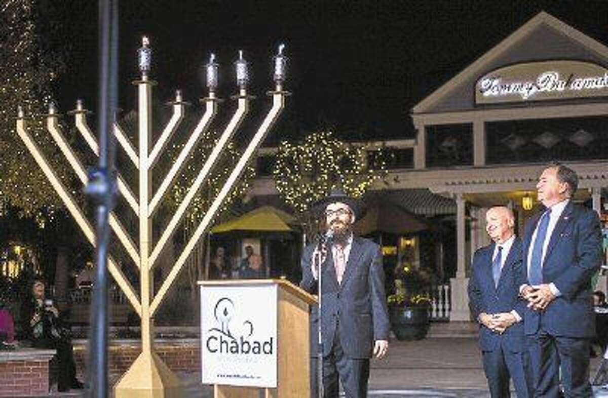 Rabbi Mendel Blecher speaks at a previous Grand Chanukah Celebration and Menorah Lighting Ceremony as U.S. Rep Kevin Brady (R-The Woodlands) and Bruce Tough, former chairman of The Woodlands Township, look on. This year’s ceremony is scheduled for Sunday at Market Street. 