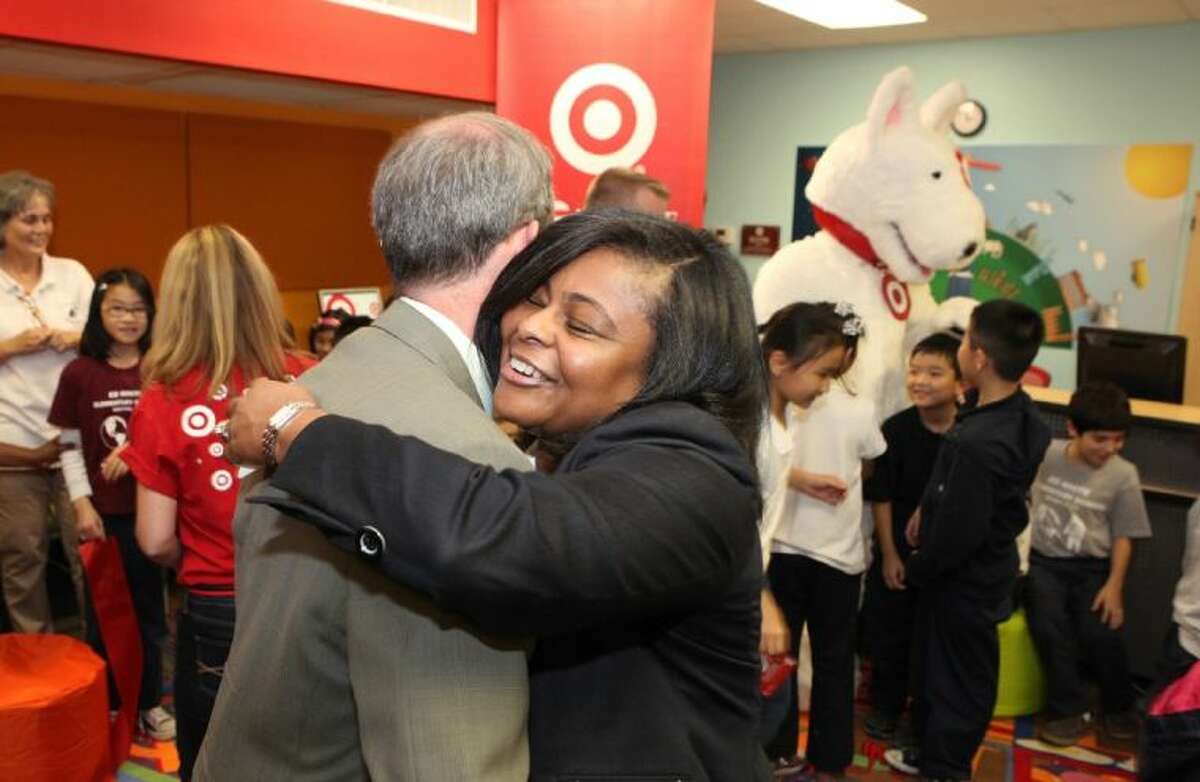 Principal Paulette Caston Bailey shares a hug with Houston ISD Trustee Greg Meyers at the unveiling of her school’s newly renovated library. The library makeover is one of 25 done this year by Target Corp. and the Heart of America Foundation.