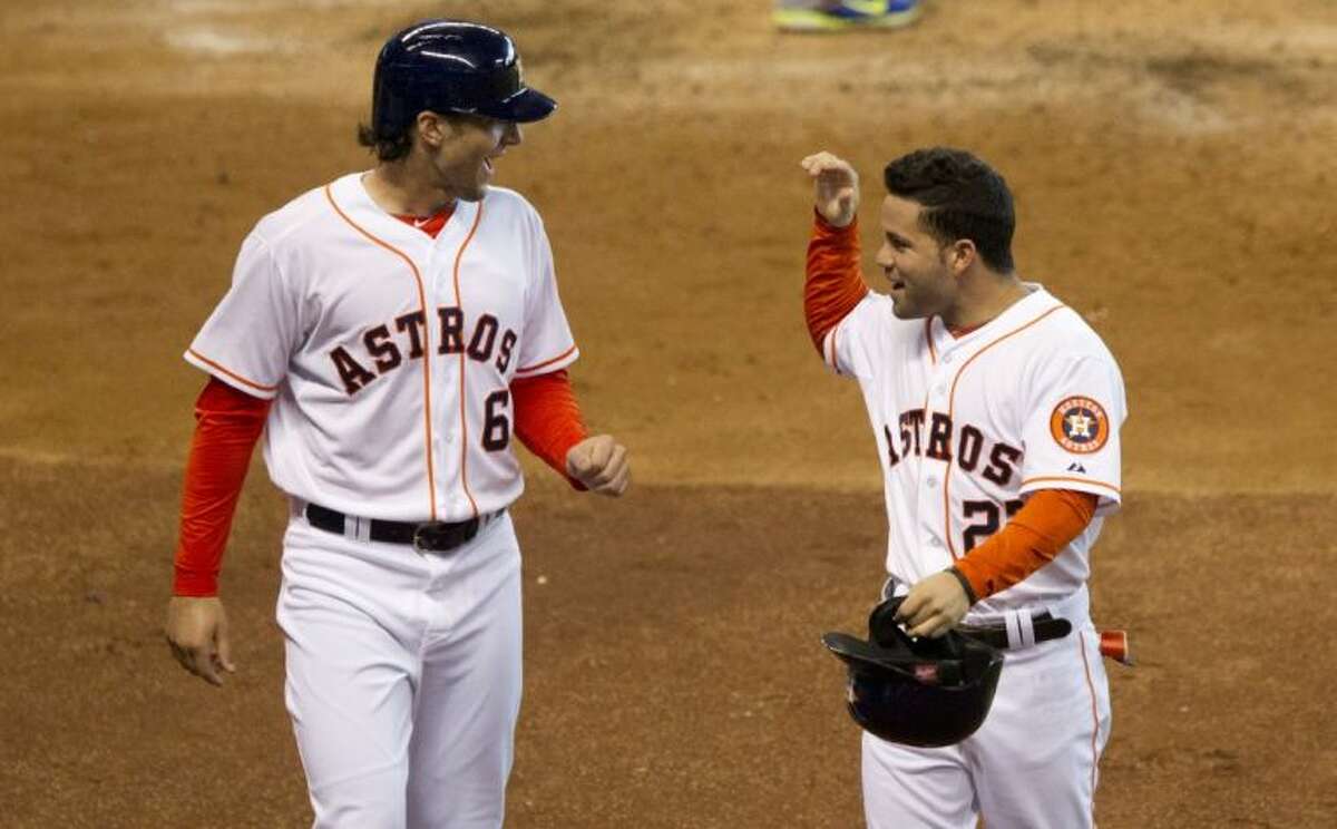 The Houston Astros' Jose Altuve (right) celebrates with teammate Jake Marisnick after they scored on Chris Carter’s second-inning single. The Astros defeated Toronto 6-1.