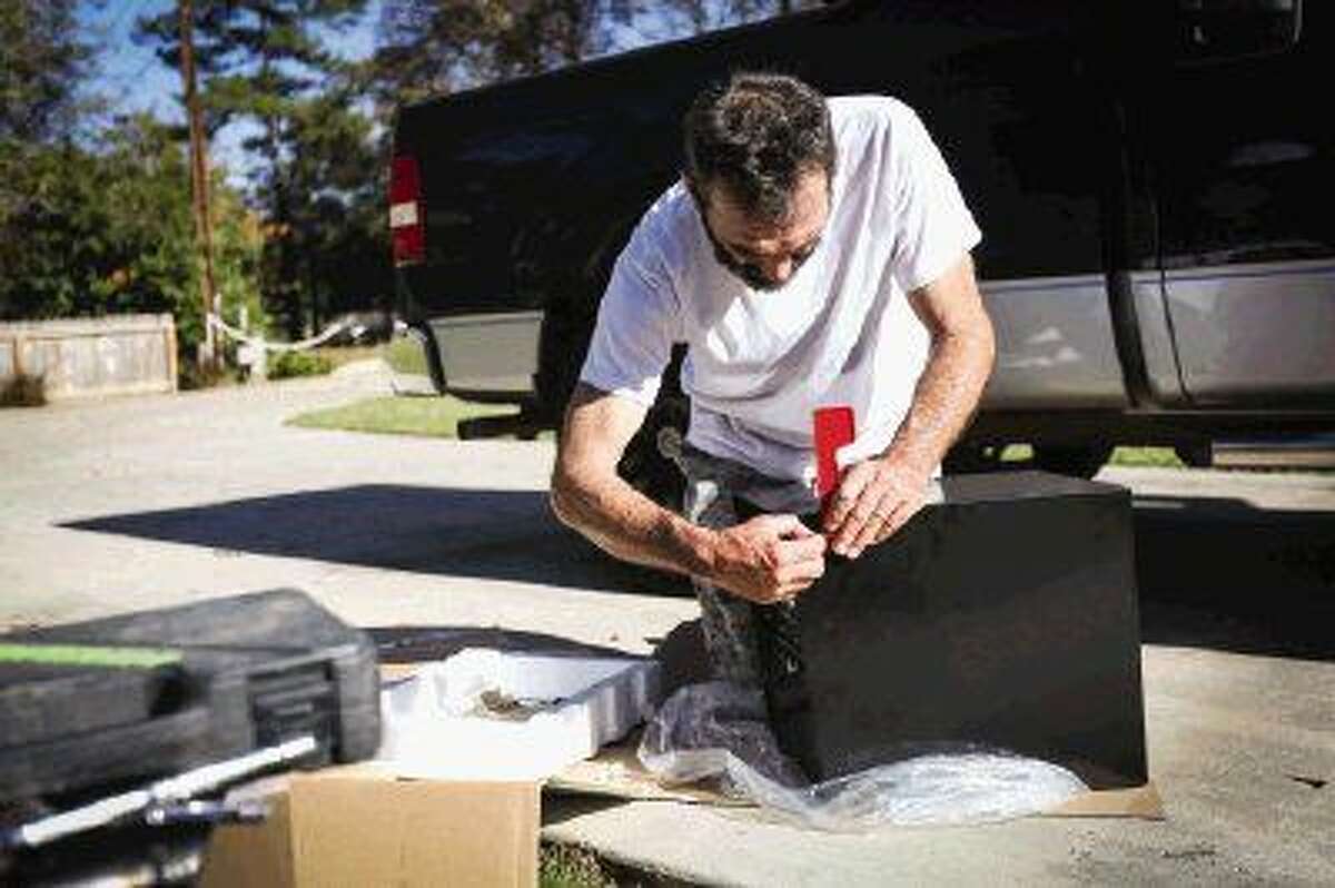 Larry Westcott installs a new mailbox outside of his home Monday in the Lake Conroe Forest subdivision after a recent string of mailbox break-ins throughout the neighborhood.