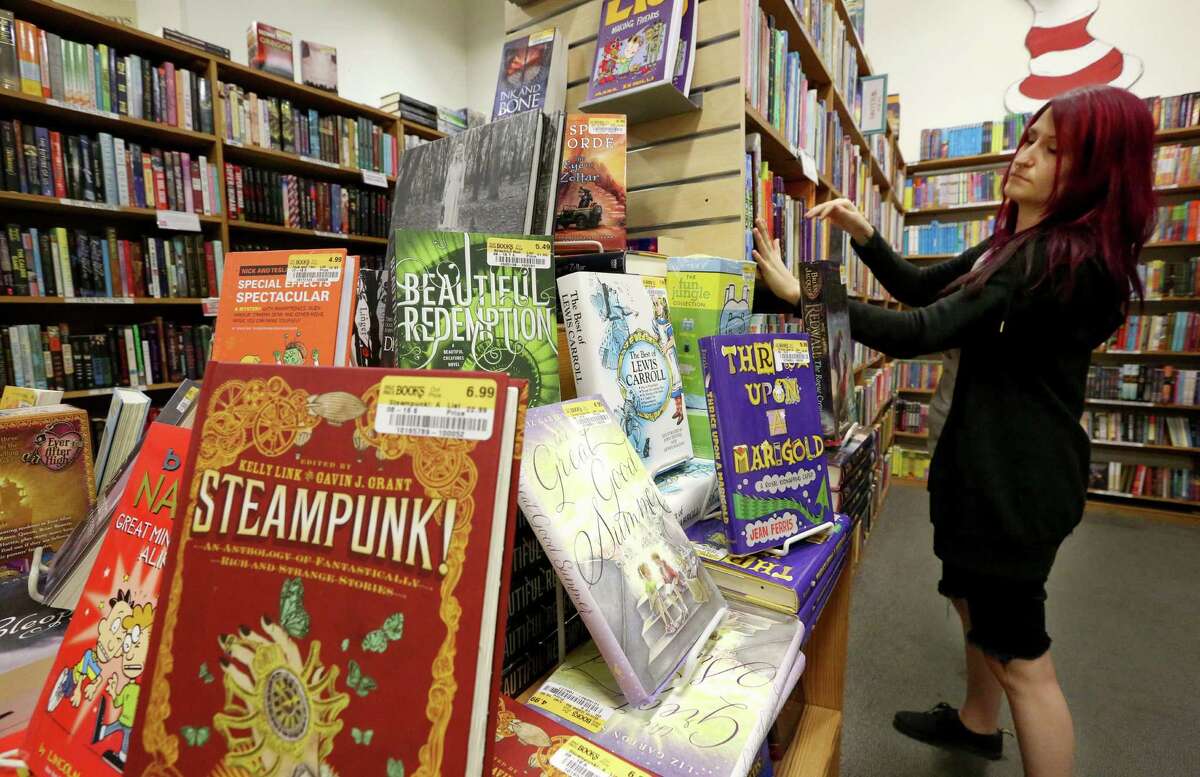 Half Price Books employee Nicole Malek organizes the bookstore's young adults section in Montrose Friday, Sept. 16, 2016, in Houston. Half Price Books stores have been expanding the young adults section as a strategy to attract more readers. ( Yi-Chin Lee / Houston Chronicle )