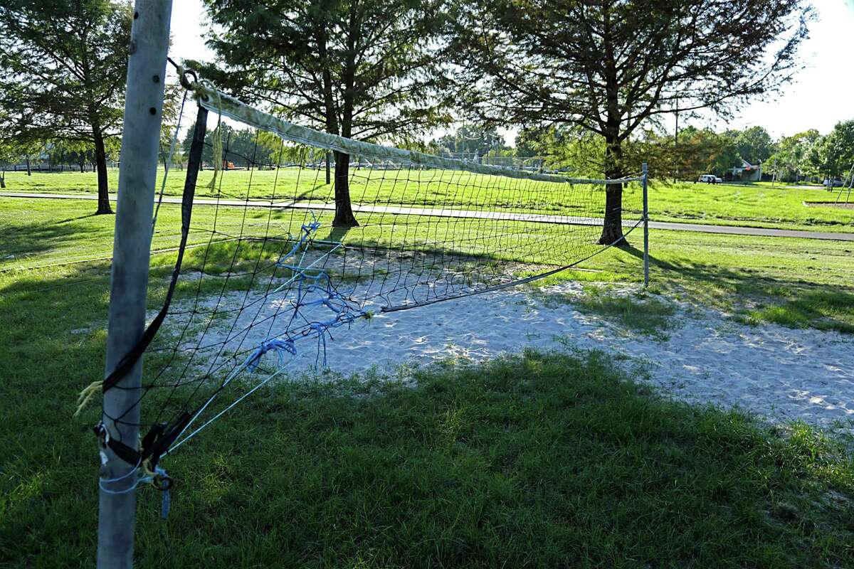 Oak Meadow Park's sand volleyball court has as much grass as sand, and residents have taken to bringing their own lawn mowers to address the problem.