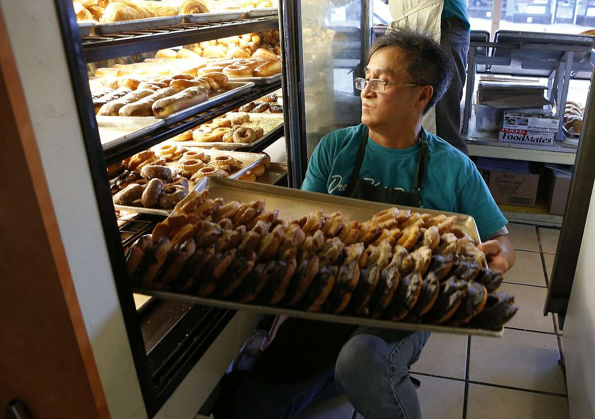 Alex Sieu rearranges a tray of donuts at his Dream Fluff donut and coffee shop in Berkeley, Calif. on Friday, Sept. 30, 2016. The Elmwood neighborhood donut shop has been a local favorite for decades.