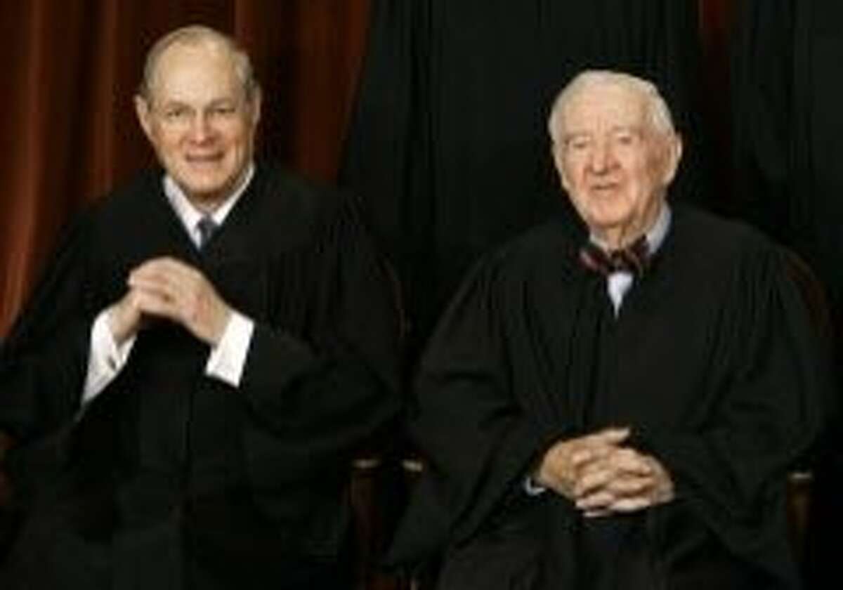 Washington, UNITED STATES: US Supreme Court justices Anthony Kennedy (L) and John Paul Stevens smile as the justices pose for their class photo 03 March 2006 inside the Supreme Court in Washington, DC. AFP PHOTO/Paul J. RICHARDS (Photo credit should read PAUL J. RICHARDS/AFP/Getty Images)