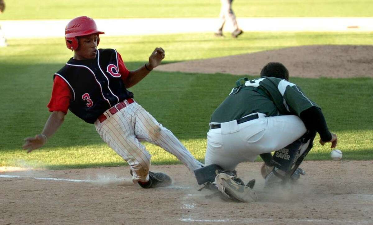Central's #3 Donte Younger slides safely into home plate as Bassick's catcher Josh Colon misses catching the ball, during Bridgeport's Baseball Classic action at the Arena at Harbor Yarb in downtown Bridgeport, Conn. on Thursday May 06, 2010.