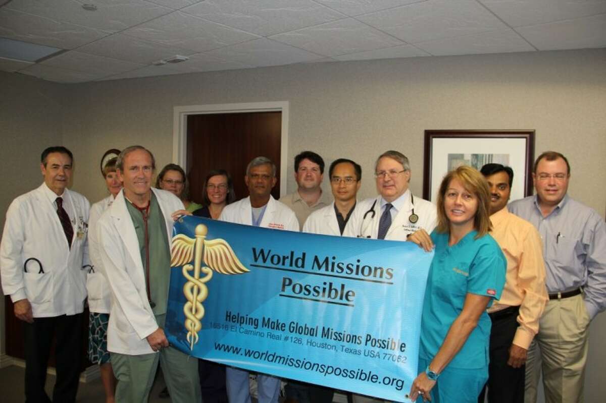 Dr. Thomas Flowers (front, holding sign) and Roxane Richter (right, holding sign), president of WMP, pictured with members of Clear Lake Regional Medical Center’s Medical Executive Committee after receiving the donation for the group’s upcoming humanitarian mission trip.