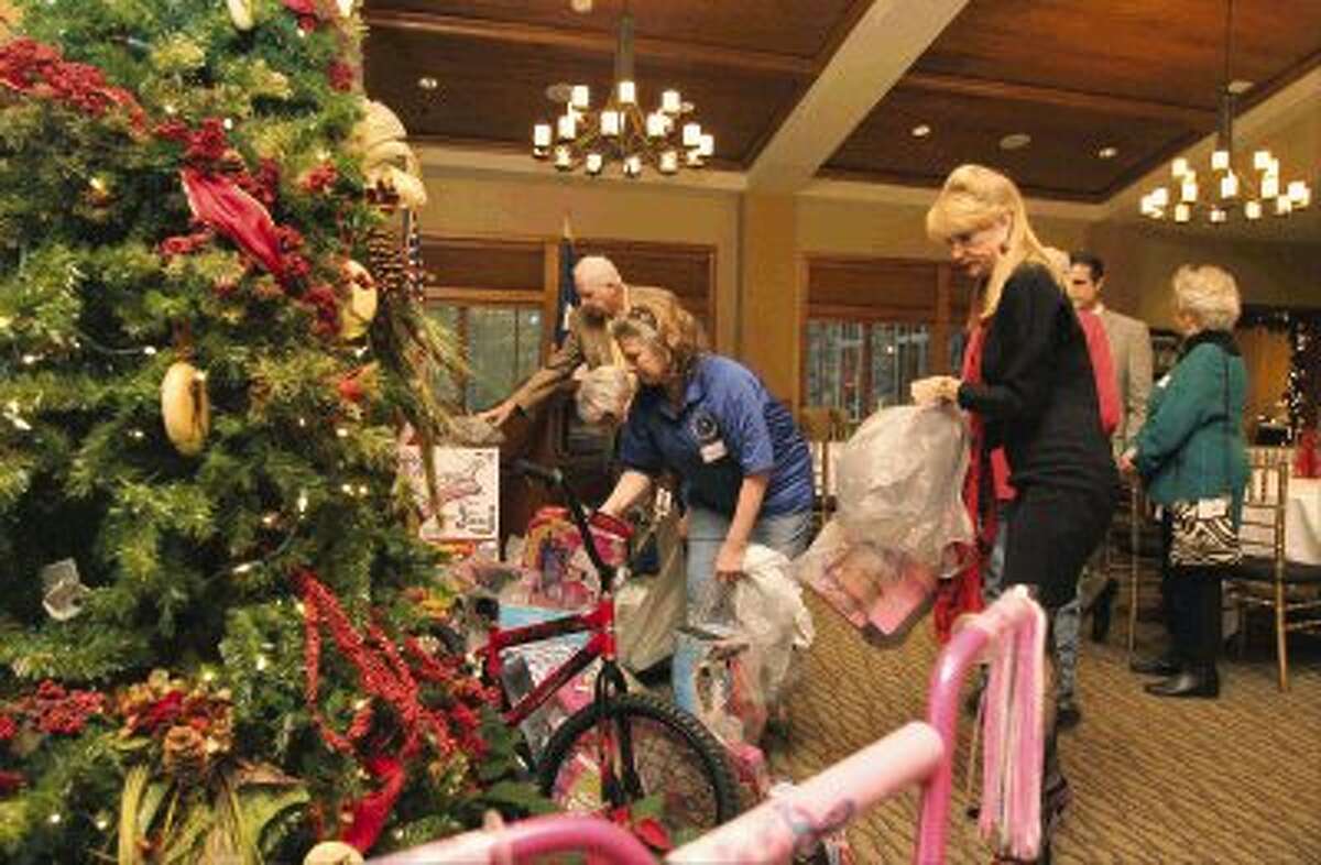 Nelda Blair and Debbie Bandfield place toys near a Christmas tree during the Third Annual Toys for Tots Montgomery County Precinct 3 Donation Party at The Woodlands Country Club Tuesday. Many state, county, and city officials and employees, business men and women and voters attended the Christmas party with Precinct 3 Commissioner James Noack. Guests were asked to bring a toy to donate for the Toys for Tots charity that gives toys to needy children in Montgomery County