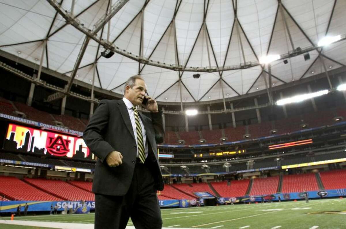 Missouri coach Gary Pinkel talks on a cellphone Friday as he waits for the Tigers’ players to arrive at the Georgia Dome ahead of Saturday’s Southeastern Conference championship game against Auburn in Atlanta.