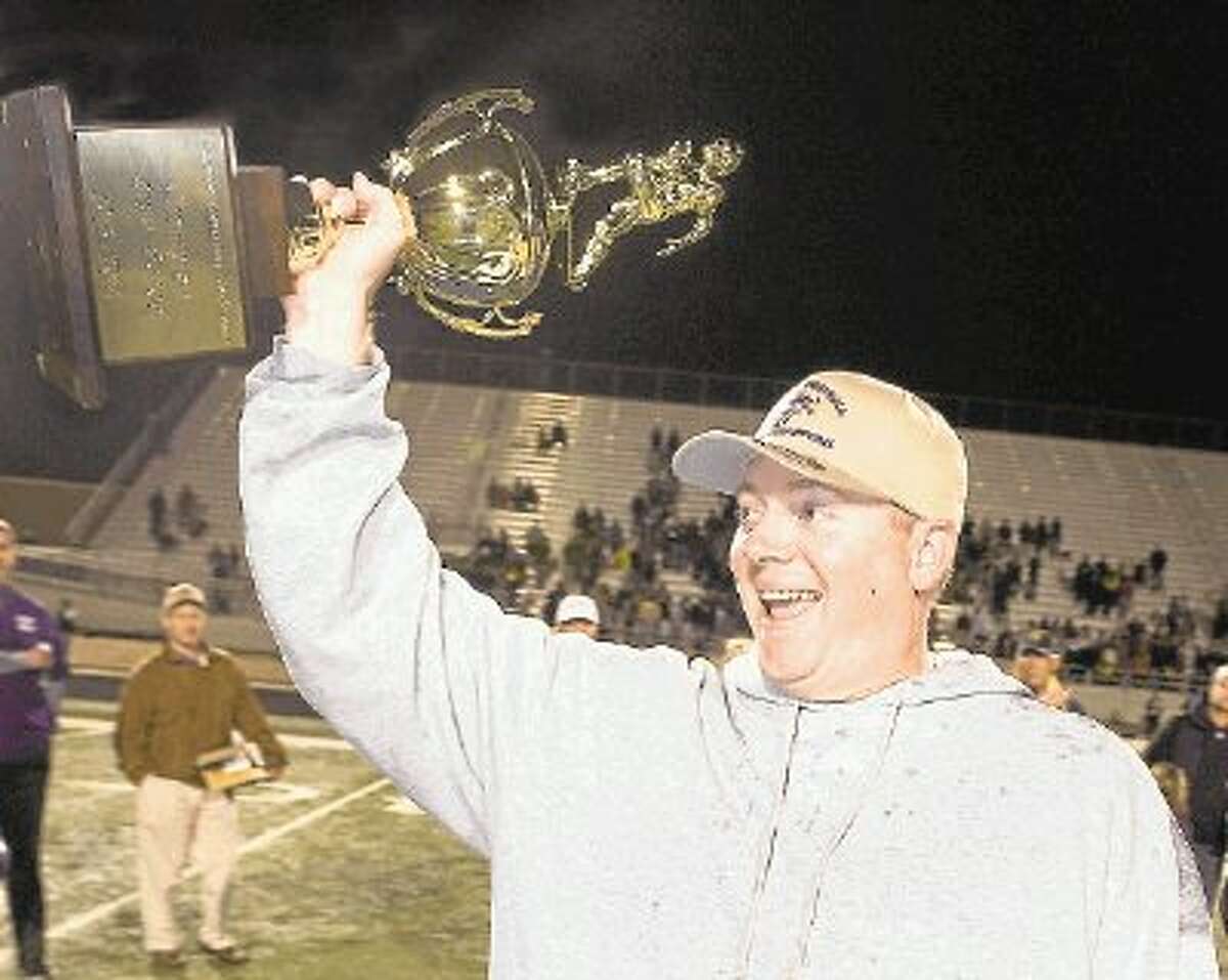 Kinkaid head football coach Nathan Larned holds up the Southwest Preparatory Conference championship trophy minutes after the Falcons defeated Dallas St. Mark’s in mid-November to win the SPC for the third time in five years. The Falcons were 11-0 this season and 6-0 after Larned took over the job from Stephen Hill midway through the season. They were also the SPC South Zone champions with a 6-0 record.