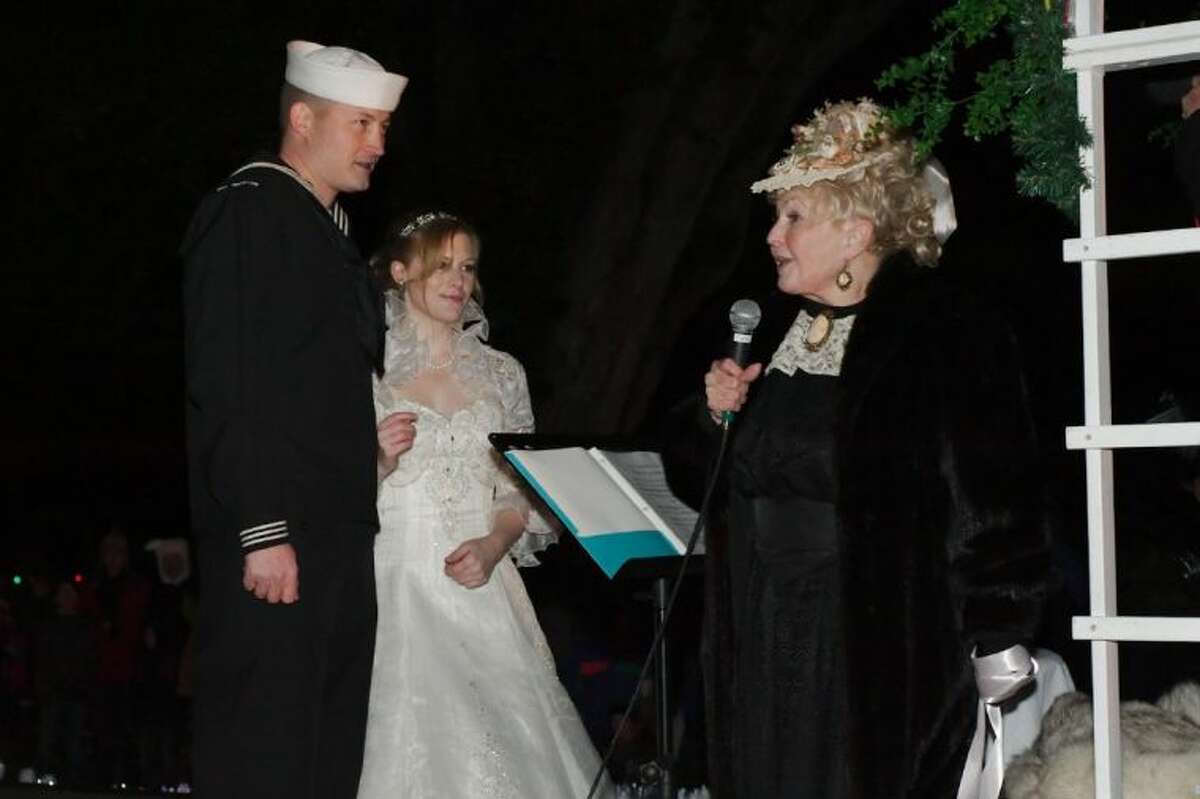 'Victorian Lady' J'Nean Henderson officiates as Navy Petty Officer 1st Class Jake Dillon and Bridget Murray celebrate their marriage during the annual League City Holiday in the Park Grand Night Parade Saturday, Dec. 7.