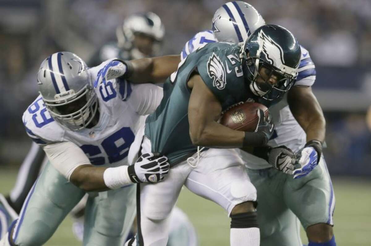 Cowboys defenders Everette Brown (71) and Corvey Irvin (69) tackle Philadelphia Eagles running back LeSean McCoy in the second half. The Eagles won 24-22.