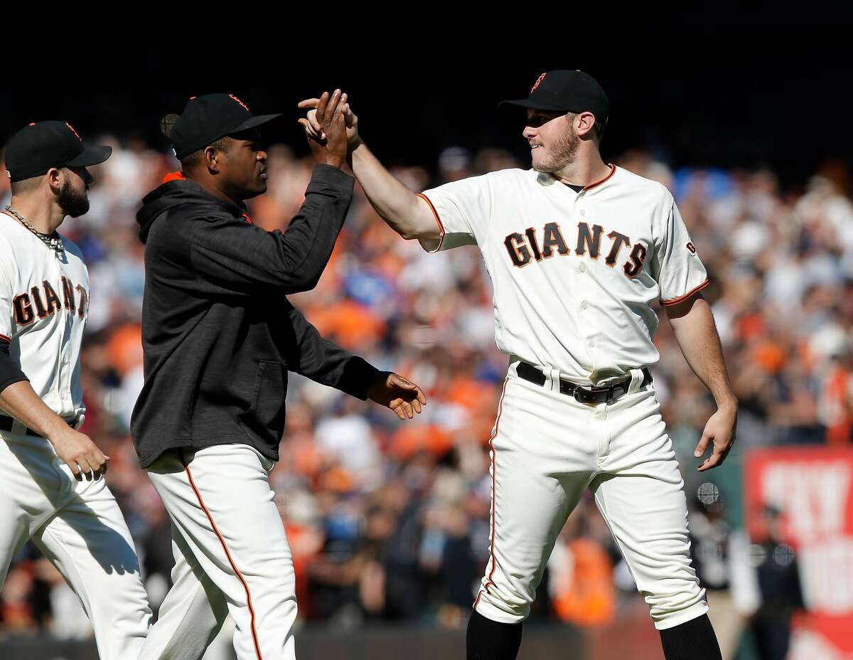 Starting Ty Blach, (right) gets a high five from Santiago Casilla at the end of the game, as the San Francisco Giants beat the Los Angeles Dodgers 3-0at AT&T Park in San Francisco, California , on Sat. Oct. 1, 2016.
