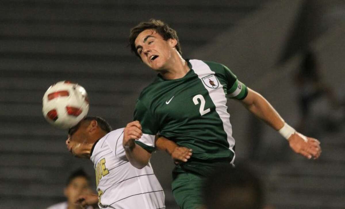 The Woodlands midfielder Vince Miller heads the ball past Conroe midfielder Jose Luis Sanchez during Tuesday night’s match. To view or purchase this photo and others like it, visit HCNpics.com.
