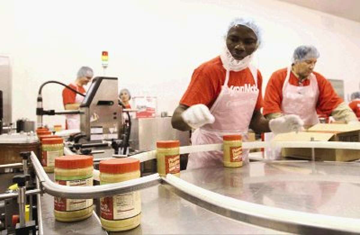 Freshly canned peanut butter slides down an assembly line to be boxed at The Church of Jesus Christ of Latter-day Saints' peanut butter cannery in Spring. A team of 20 volunteers can produce 6,000 containers of peanut butter every four hours. Go to HCNPics.com to view more photos of how the peanut butter is made.