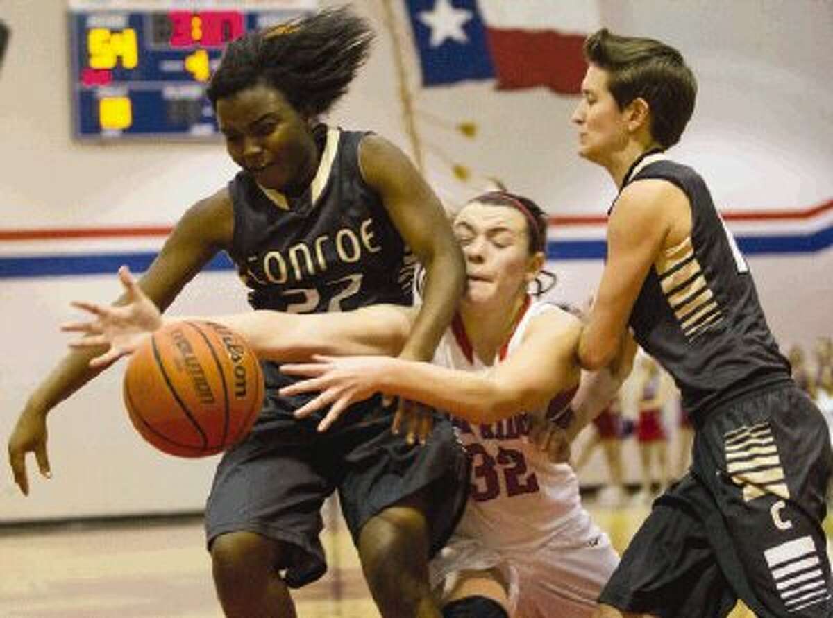 Conroe’s Alexis Lewis (22), Oak Ridge’s Kelsey Scibek (32) and Conroe’s Lauren George (12) struggle for the ball before it goes out of bounds during a basketball game on Tuesday night at Oak Ridge High School. The Lady War Eagles won 61-57. Go to HCNPics.com to view and purchase this photo, and others like it.