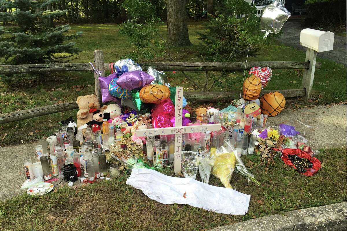 In this Sept. 27, 2016 photo, a memorial for Nisa Mickens and Kayla Cueva is located near the locations where their bodies were found in Brentwood, N.Y. The girls, who were best friends, were found murdered. Multiple teenagers from the same Long Island high school have been found dead and while police suspect all the deaths are related to gang violence, they are releasing few details. (AP Photo/Claudia Torrens) ORG XMIT: RPCT103